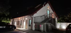 a white building with a staircase on it at night at Volare Balice in Cholerzyn