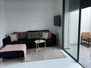 a living room with a black couch and a table at Sabir Hadaj in Kenitra