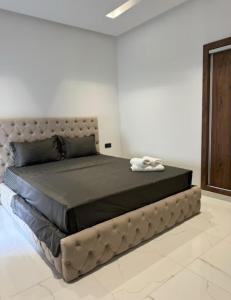 a bedroom with a large bed with a leather headboard at Sabir Hadaj in Kenitra