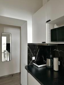 a kitchen with a black counter top and a mirror at Dolce Vita Budapest in Budapest +57 photos