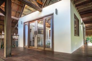 an open room with glass doors and wooden ceilings at Libertad Surf Villa in General Luna +14 photos
