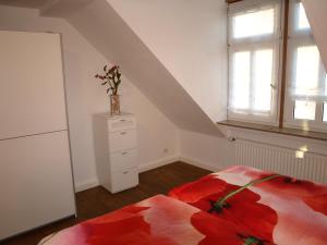 a bedroom with a bed and a dresser and a window at Ferienwohnung Klatschmohn in Speyer