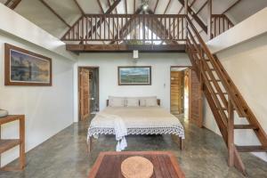 a bedroom with a large bed and a staircase at Libertad Surf Villa in General Luna