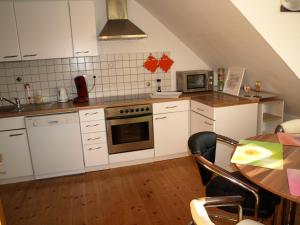 una cocina con armarios blancos y una mesa con mesa en Ferienwohnung Klatschmohn en Espira