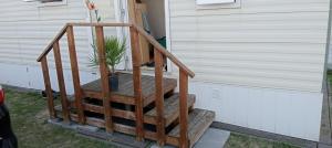 a wooden staircase next to a house with a potted plant at Les Tournesols in Middelkerke