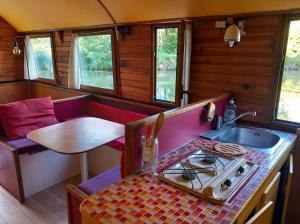 a small kitchen with a sink and a table at Bateau sur le Canal du Midi in Ramonville-Saint-Agne
