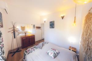 a bedroom with a bed and a dresser in it at Bungalow PITAYA dans jardin tropical proche lagon in Saint-Gilles les Bains