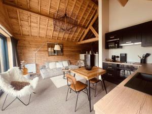 a living room with a couch and a table at Les pavillons de La Libellule in Beauraing