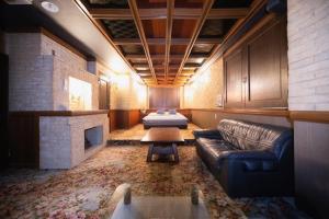 a living room with a couch and a fireplace at ホテルピースプラス in Kamisu