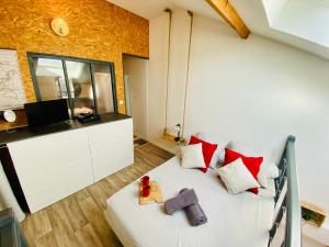 een slaapkamer met een bed met rode en witte kussens bij Duplex industriel - Centre ville Parking privé WIFI in Angers