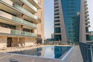 a swimming pool in a building with two tall buildings at Lusail House in Doha