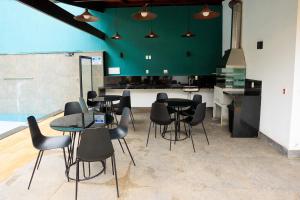 a room with tables and chairs and a green wall at Pousada Vinháticos in Nova Lima
