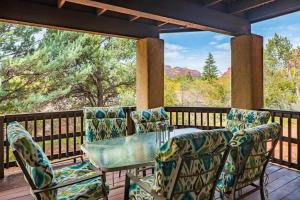 a patio with a glass table and chairs on a deck at Spacious Sedona Splendor with Community Spa & Pool in Sedona