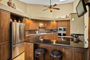 a kitchen with wooden cabinets and a stainless steel refrigerator at Spacious Sedona Splendor with Community Spa & Pool in Sedona +43 photos