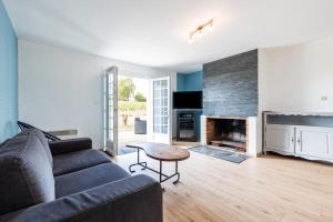 a living room with a couch and a fireplace at Maison Cœur Des Vignes in Les Salles-de-Castillon