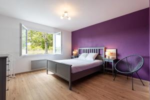 a bedroom with a bed and a purple wall at Maison Cœur Des Vignes in Les Salles-de-Castillon +16 photos