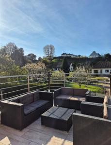 a patio with couches and tables and a fence at Le Millésime in Eu
