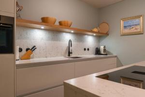 a kitchen with a sink and a counter at Hello Zeeland - Appartement Park loverendale 25 in Domburg