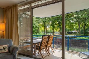 a dining room with glass doors and a table and chairs at Hello Zeeland - Appartement Park loverendale 25 in Domburg +24 photos