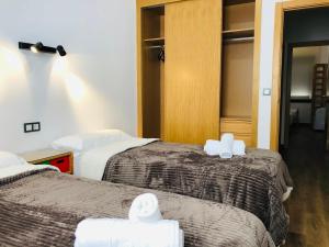a hotel room with two beds with white towels on them at ROOMS Malaga Centro Jinetes in Málaga