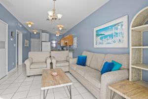 un soggiorno con un divano e un tavolo di Baywatch F-3 a Villa Sabine