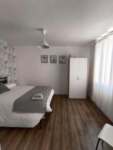 a bedroom with a bed and a white cabinet at L'appart de Cécile in Bellegarde-sur-Valserine