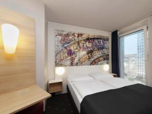 Un dormitorio con una cama y un cuadro en la pared. en B&B HOTEL Berlin-Alexanderplatz, en Berlín