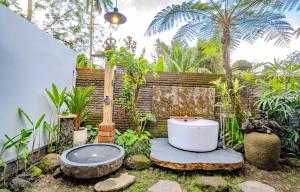 y baño con bañera en el jardín. en Imagine Bali, en Ubud