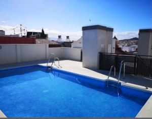 a swimming pool on the roof of a building at ROOMS Malaga Centro Jinetes in Málaga