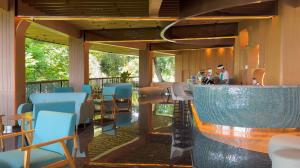 un restaurant avec des chaises bleues et un bar dans l'établissement Hotel Santika Premiere Hills Resort Cibadak Sukabumi, à Cibadak