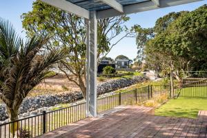 un sentiero che conduce a un cortile con una recinzione e alberi di Coastal Escape - Waihi Beach Holiday Home a Waihi Beach