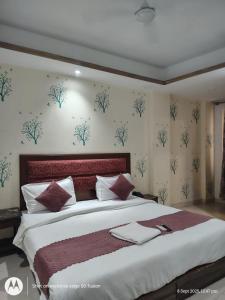 a bedroom with a large bed with a red headboard at Hotel Banke Bihari Stays in Vrindāvan