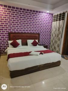 a bedroom with a large bed with a brick wall at Hotel Banke Bihari Stays in Vrindāvan