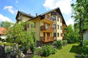 an apartment building with balconies and a fence at Apartament 24 Karpacz in Karpacz
