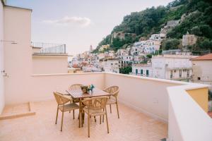 a table and chairs on a balcony with a view at Residenza Dea Amalfi in Amalfi