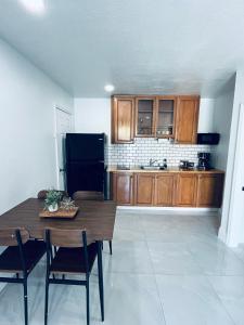 a kitchen with a wooden table and a black refrigerator at Perfect go away in Fort Myers +3 photos