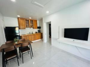 a kitchen with a table and a television on a wall at Perfect go away in Fort Myers