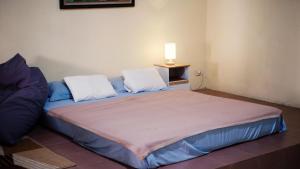 a bedroom with a large bed with two pillows at Pondok Kalimaya in Serang