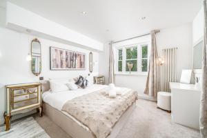 una camera da letto bianca con un letto e una finestra di Maida Vale Camille a Londra