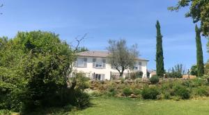 a large white house with trees in a yard at Les hauts de Merfy maison 5 chambres avec piscine 