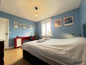 a bedroom with a large bed with blue walls at Les hauts de Merfy maison 5 chambres avec piscine  +60 photos
