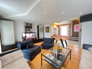 a living room with couches and a ping pong table at Les hauts de Merfy maison 5 chambres avec piscine 
