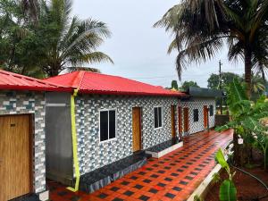a small house with a red roof at Shri Ishwari home stay Murdeshwar in Māvalli