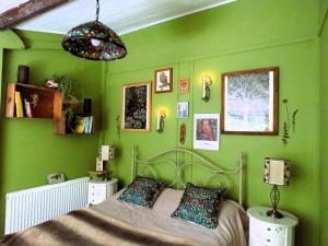 a bedroom with green walls and a bed in it at Bluebell Cottage At Lurley Manor in Washfield