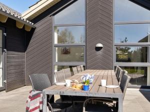 a patio with a wooden table and chairs at Holiday Home Lova - 600m from the sea by Interhome in Blåvand