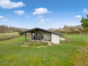 a small white shed with a pitched roof in a field at Holiday Home Jule - 1-3km to the inlet by Interhome in Lihme