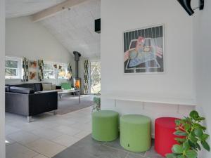a living room with green and red stools at Holiday Home Lova - 600m from the sea by Interhome in Blåvand