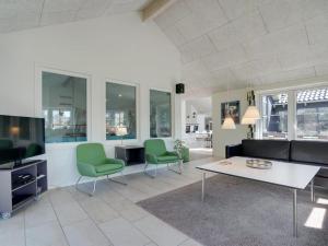 a living room with a couch and a table and chairs at Holiday Home Lova - 600m from the sea by Interhome in Blåvand +29 photos