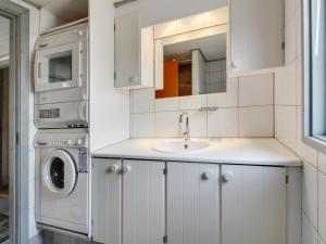 a white kitchen with a sink and a washer and dryer at Holiday Home Tala - 4km from the sea by Interhome in Blåvand +16 photos