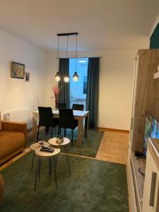 a living room with a table and a couch at Nest24- cozy apartment with terrace and private garage in Niš